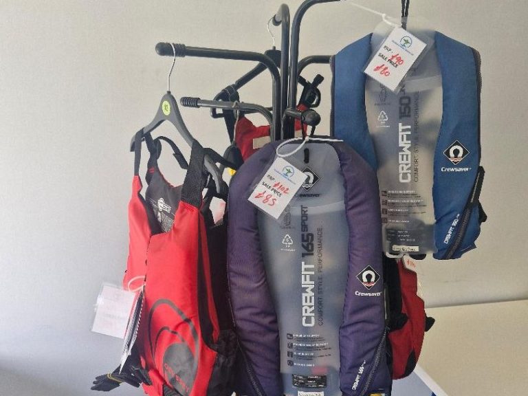 Display of various coloured life jackets on hangers.