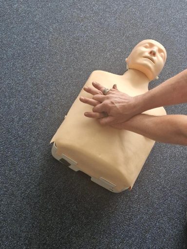 Someone performing CPR on a dummy
