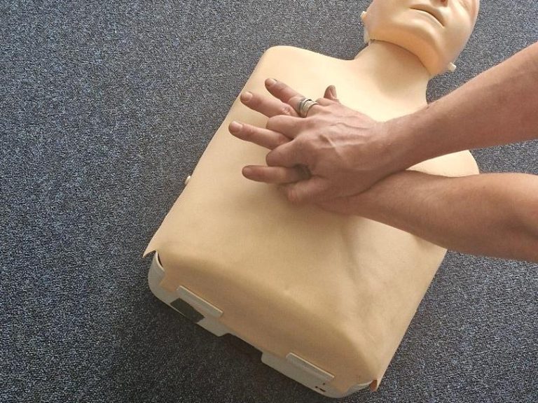 Someone performing CPR on a dummy