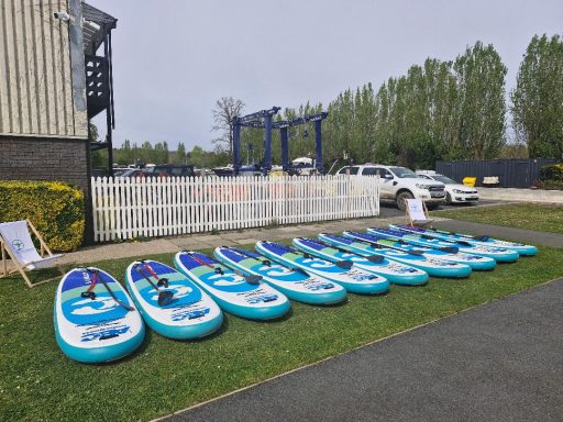 Row of paddle boards laid out on the lawn