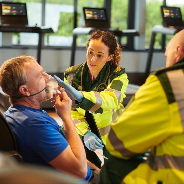 Paramedics assisting a man with an oxygen mask